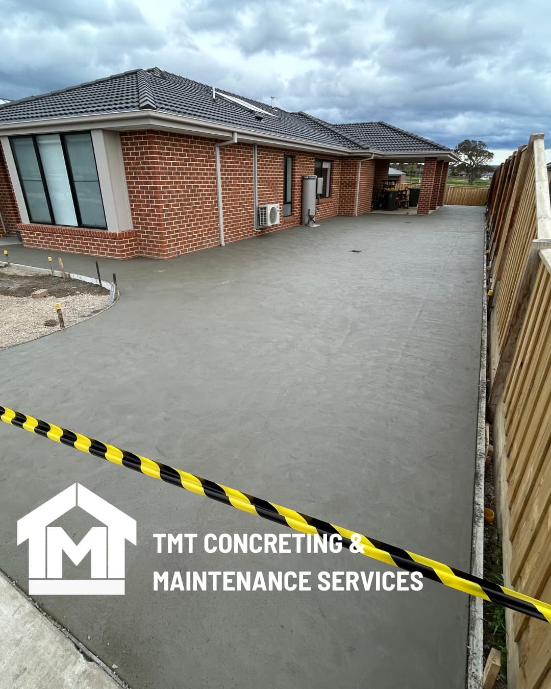 Concrete driveway with fence line, Gippsland project by TMT Concreting