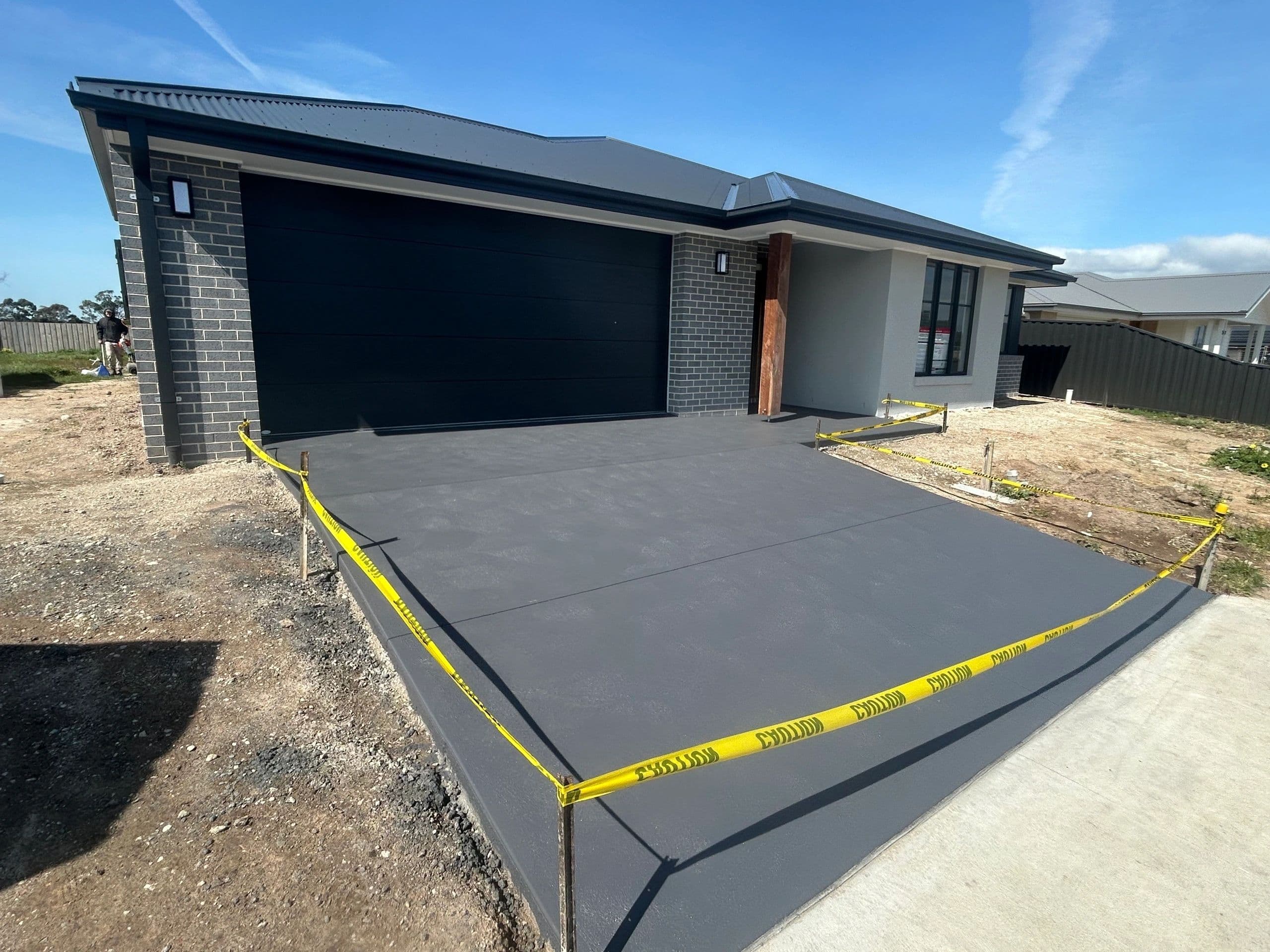 New coloured concrete driveway on a new house · Gippsland — TMT Concreting & Maintenance