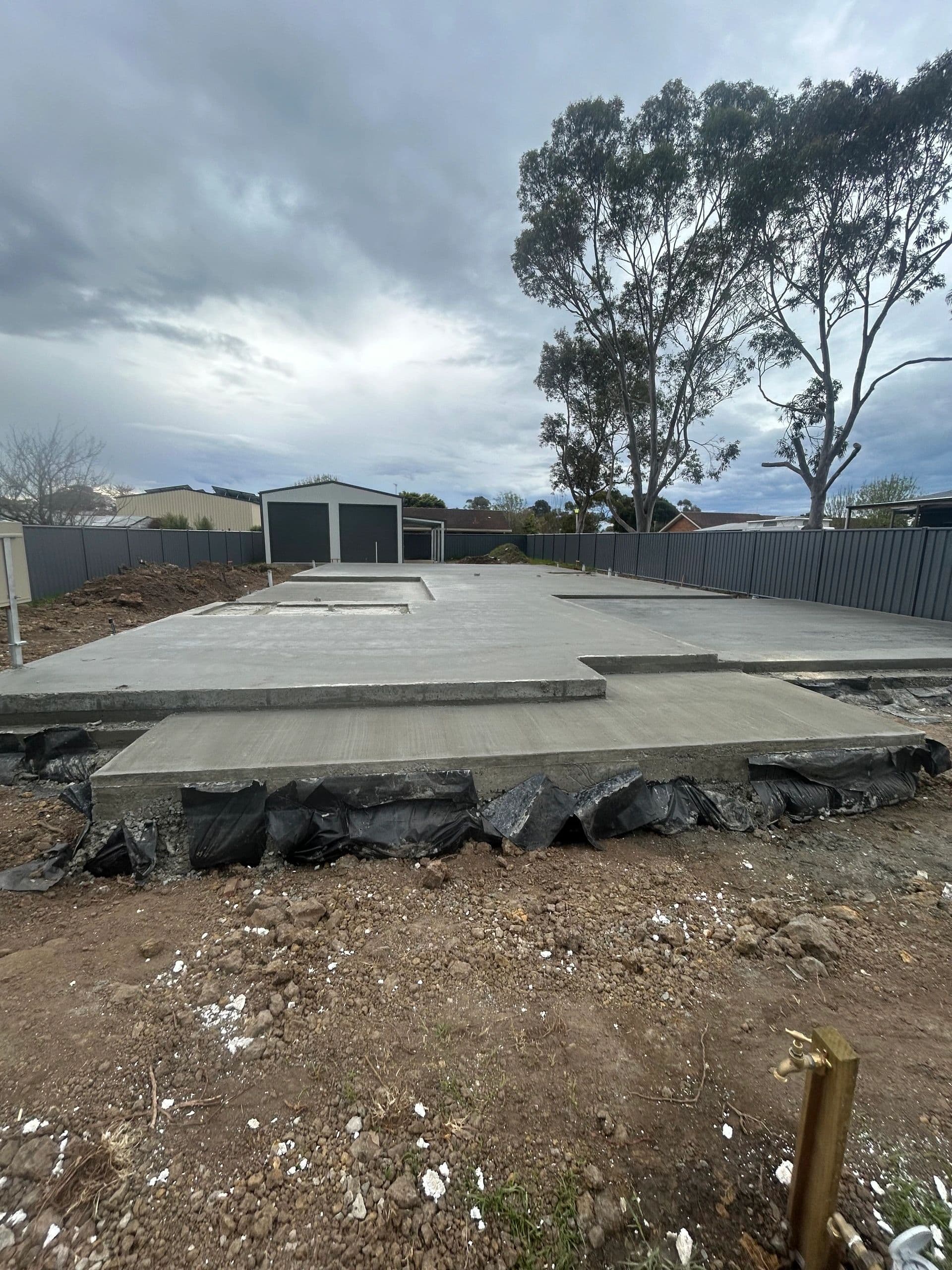 House slab with shed in background · Heyfield — TMT Concreting & Maintenance
