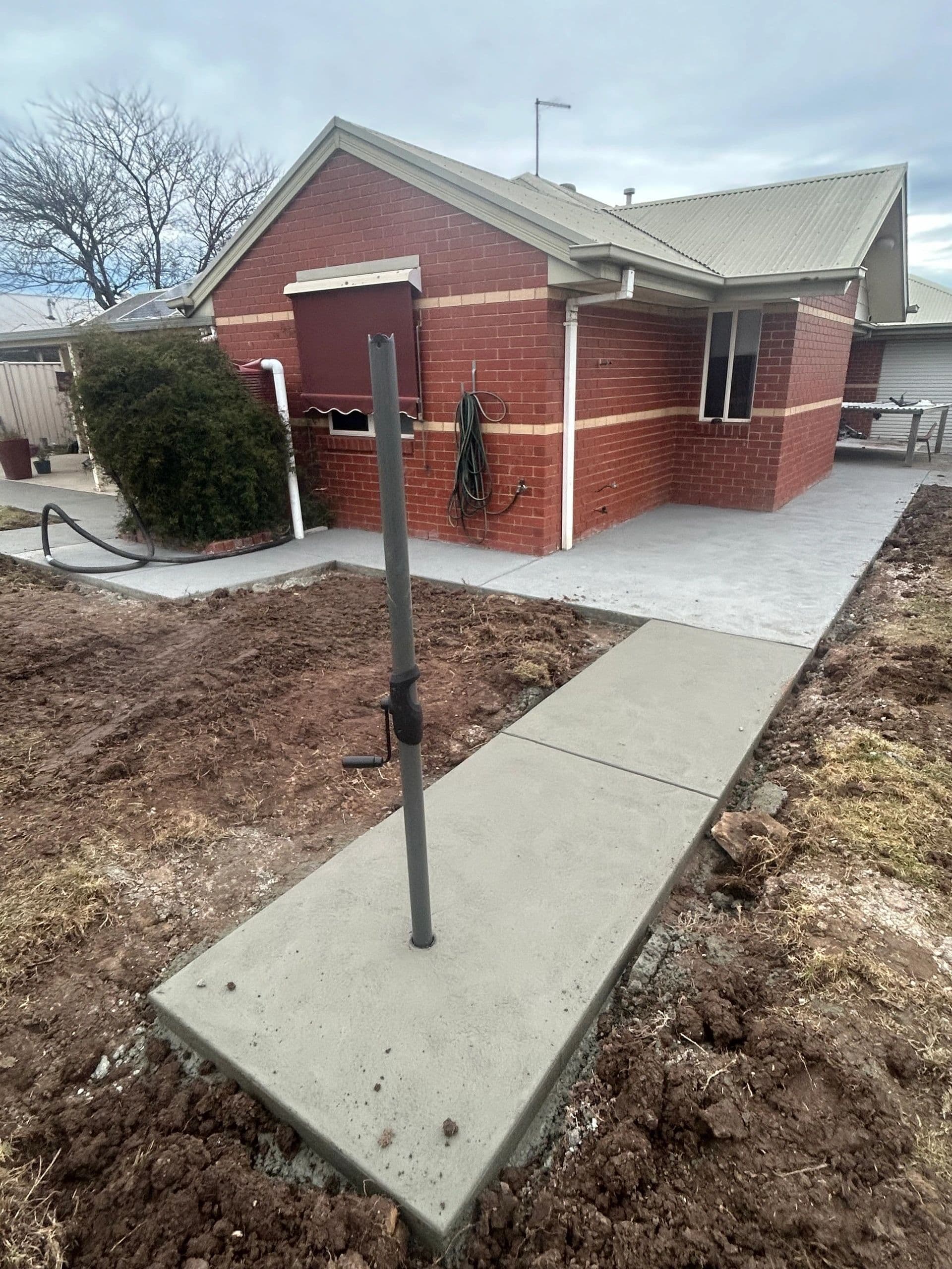 Concrete footpath beside washing line · Gippsland — TMT Concreting & Maintenance