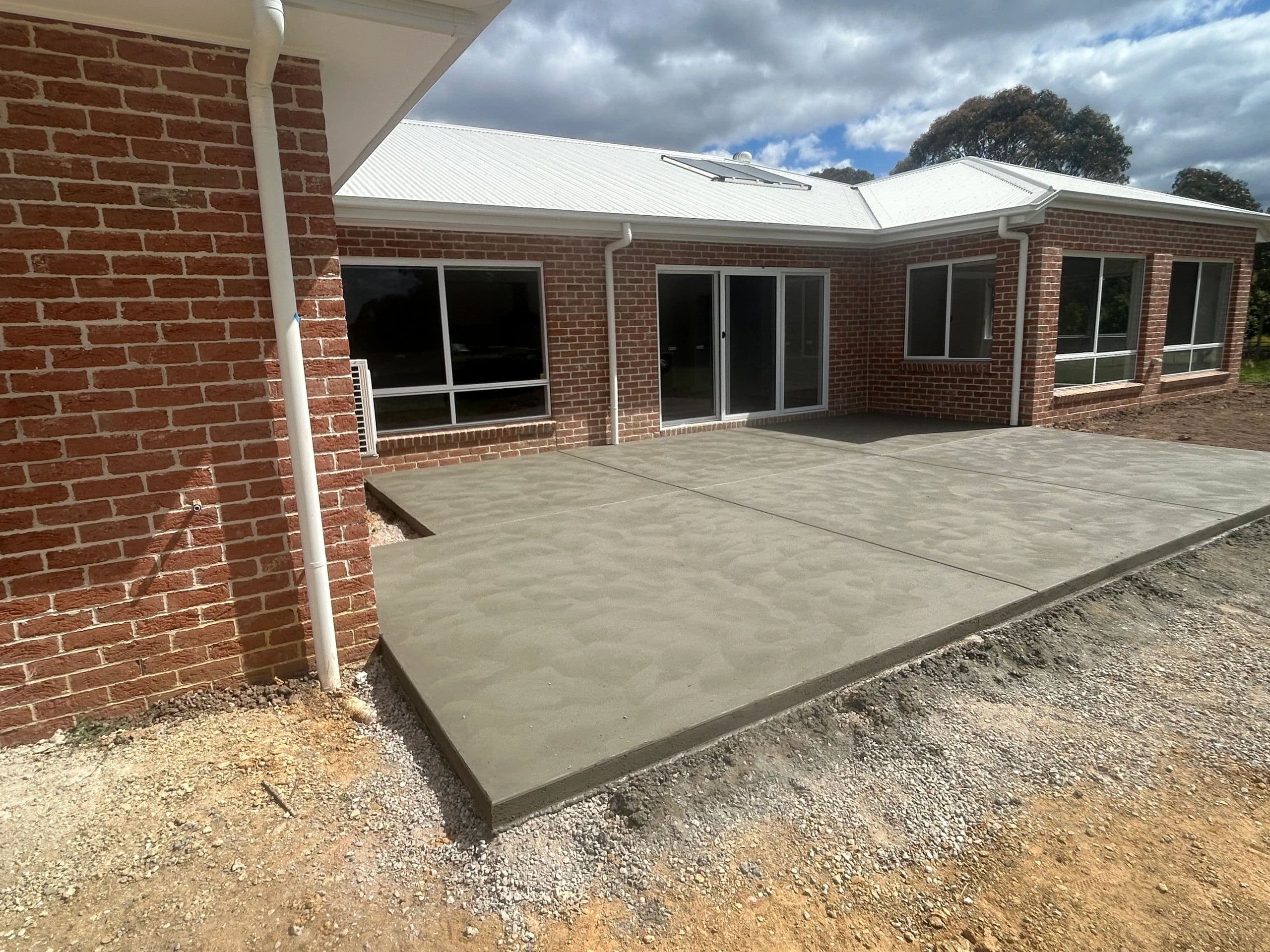 Patio extension in plain concrete with non-slip finish · Longford — TMT Concreting & Maintenance